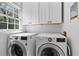 Bright laundry room with side-by-side washer and dryer and white storage cabinets at 4257 Edgewater Nw Dr, Kennesaw, GA 30144