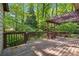 Wood deck featuring natural wood railing, pergola, and access to lush backyard at 3200 Turtle Lake Se Ct, Marietta, GA 30067