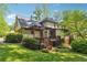 Exterior view of home with wood deck, wooded surround, and lush green lawn at 3200 Turtle Lake Se Ct, Marietta, GA 30067