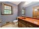 Cozy bathroom featuring a unique vanity with a red countertop and blue patterned walls with a window at 3200 Turtle Lake Se Ct, Marietta, GA 30067