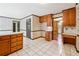 Classic eat-in kitchen with white tile floor, wood cabinets and trim, and a view to the dining area at 3200 Turtle Lake Se Ct, Marietta, GA 30067
