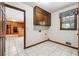 Well-lit laundry room featuring overhead cabinets and a view into the kitchen, designed for functionality at 3200 Turtle Lake Se Ct, Marietta, GA 30067