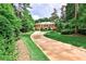 Stately red brick home with a long driveway surrounded by lush greenery at 3370 Habersham Nw Rd, Atlanta, GA 30305