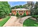 Elegant brick home features a circular driveway, beautiful landscaping, and a classic design with black shutters and a chimney at 3370 Habersham Nw Rd, Atlanta, GA 30305