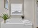 Bright bathroom featuring a soaking tub beneath a window for natural light at 3510 Meadow Grass Dr, Dacula, GA 30019