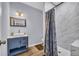 Stylish bathroom with a blue vanity, modern sink, and a beautiful shower with a curtain at 3510 Meadow Grass Dr, Dacula, GA 30019
