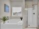 Bright bathroom featuring a soaking tub and a separate shower with gold trim at 3510 Meadow Grass Dr, Dacula, GA 30019