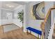 Entryway featuring wood-look floors, bench seating, and modern artwork; stairs to the right at 3510 Meadow Grass Dr, Dacula, GA 30019