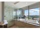 Bright bathroom offering a soaking tub, shower, and scenic city views through large windows at 3344 Peachtree Ne Rd # 3601, Atlanta, GA 30326