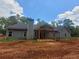 Back exterior featuring a covered patio and a large yard surrounded by trees at 879 Highway 101 N, Dallas, GA 30157