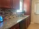 Well-appointed kitchen with granite countertops, stainless steel appliances, and a stylish mosaic tile backsplash at 487 Cypher Dr, Suwanee, GA 30024