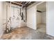Unfinished basement featuring concrete floors, block walls, pipes and doorway at 535 Transit Cir, Atlanta, GA 30349