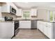 Galley kitchen with granite countertops, stainless steel appliances, and white cabinetry at 535 Transit Cir, Atlanta, GA 30349