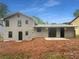 Back exterior view of home featuring gray siding, with a small patio and space for a garden at 1950 Matthew Way, Lithonia, GA 30058