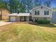 Charming split-level home featuring a well-maintained lawn, gray siding, and a one car garage at 1950 Matthew Way, Lithonia, GA 30058