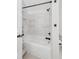 Modern tub-shower with white tile and dark fixtures at 2244 Spink Nw St, Atlanta, GA 30318