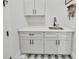 Well-organized laundry room with white cabinetry, modern fixtures, and stylish star-patterned tile flooring at 2244 Spink Nw St, Atlanta, GA 30318