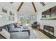 Cozy living room features a vaulted ceiling with beams, a fireplace, a gray sectional sofa, and natural light at 2244 Spink Nw St, Atlanta, GA 30318