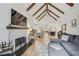 Open-concept living room with a fireplace, wood beams, hardwood floors, and an adjacent dining and kitchen area at 2244 Spink Nw St, Atlanta, GA 30318