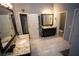 A spacious bathroom featuring double vanities, tile flooring, and separate toilet room at 6147 Pritchett Dr, Powder Springs, GA 30127