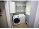 Well-organized laundry room featuring modern washer and dryer with shelves for storage at 6147 Pritchett Dr, Powder Springs, GA 30127