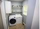 A conveniently located laundry room with modern washer, dryer, and shelving at 6147 Pritchett Dr, Powder Springs, GA 30127