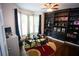 Well-lit home office with custom built-in shelving and large bay window at 6147 Pritchett Dr, Powder Springs, GA 30127