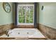 Soaking tub under a bright window with a garden view for a spa-like experience at 682 Leighton Way, Stone Mountain, GA 30088
