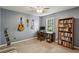 Study room with a wooden desk, bookshelf, and music instruments for work and hobbies at 682 Leighton Way, Stone Mountain, GA 30088