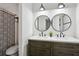 Bathroom features double sinks with round mirrors, wood cabinets, and a shower behind a striped curtain at 321 Hickory Sw Walk, Marietta, GA 30064