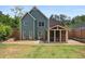 Back of home with a sunroom addition and a large, grassy backyard and stone retaining wall at 321 Hickory Sw Walk, Marietta, GA 30064