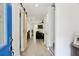 Bright hallway featuring light wood floors, white walls, and a sliding barn door to the living spaces at 321 Hickory Sw Walk, Marietta, GA 30064