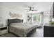 Cozy main bedroom with gray tufted headboard, ceiling fan, and a window for natural light at 321 Hickory Sw Walk, Marietta, GA 30064