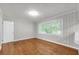Cozy bedroom with hardwood floors, a large window, and light, neutral wall paneling at 2740 Pasco Se Ln, Atlanta, GA 30316