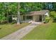 Charming single-story home with a covered carport, and lush green lawn surrounded by mature trees at 2740 Pasco Se Ln, Atlanta, GA 30316