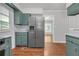 The kitchen features stainless steel refrigerator and retro green cabinets on beautiful hardwood floors at 2740 Pasco Se Ln, Atlanta, GA 30316
