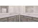 Bathroom featuring dual sinks with marble countertops and gray cabinets at 460 Reflection Dr # 21, Stockbridge, GA 30281