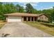 Charming brick ranch home featuring a two-car garage and a long driveway, surrounded by mature trees at 2944 Williams Pl, Snellville, GA 30078