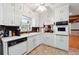 Well-lit kitchen featuring white cabinets, brick accents, and modern appliances for a blend of style and functionality at 2944 Williams Pl, Snellville, GA 30078
