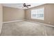 Spacious bedroom featuring neutral carpet, beige walls, a window with blinds, and ceiling fan at 4499 Bellemeade Dr, Douglasville, GA 30135