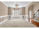 Bright carpeted dining room with chandelier and wainscoting offers ample space at 4499 Bellemeade Dr, Douglasville, GA 30135