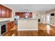 Bright kitchen with wood cabinets, stainless steel appliances, and granite countertops, with an island bar and wood floors at 4499 Bellemeade Dr, Douglasville, GA 30135