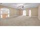 Open-concept living room with beige walls, carpet, a ceiling fan, and arched entryways to other rooms at 4499 Bellemeade Dr, Douglasville, GA 30135