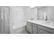 Bright bathroom featuring double vanities, a bathtub, and a glass-enclosed shower at 5853 Greystone Dr, Lithonia, GA 30058