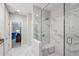 Luxurious bathroom with a marble walk-in shower, built-in bench, and open doorway to a bedroom at 613 Brennan Dr, Decatur, GA 30033