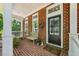Charming brick porch featuring a bench, plants, and black front door with glass panels at 613 Brennan Dr, Decatur, GA 30033
