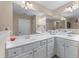 Bright bathroom with double vanity, white cabinetry, and large mirror at 661 Village Field Nw Ct, Suwanee, GA 30024