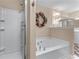 Bright bathroom features a shower, jacuzzi tub, white cabinets and floral accents at 661 Village Field Nw Ct, Suwanee, GA 30024