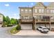 Exterior view of multi-story townhome showcasing private garages and spacious outdoor decks for entertaining at 661 Village Field Nw Ct, Suwanee, GA 30024