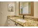 Bathroom vanity with a granite countertop, a stylish faucet, and a decorative framed mirror at 3107 Woodland Ln, Alpharetta, GA 30009